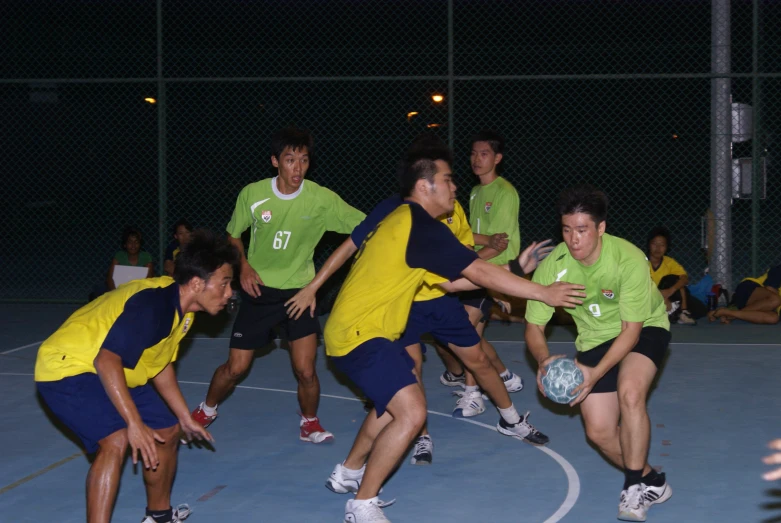 a group of men in green and yellow uniforms playing soccer