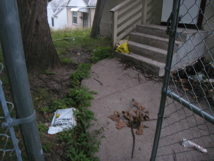 a dirty yard next to stairs with a sign