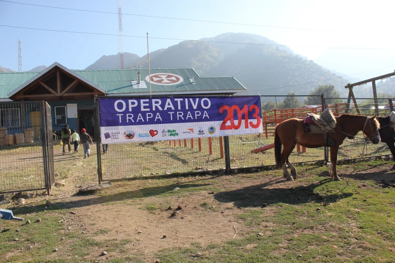 there is a horse that has a sign posted on the fence