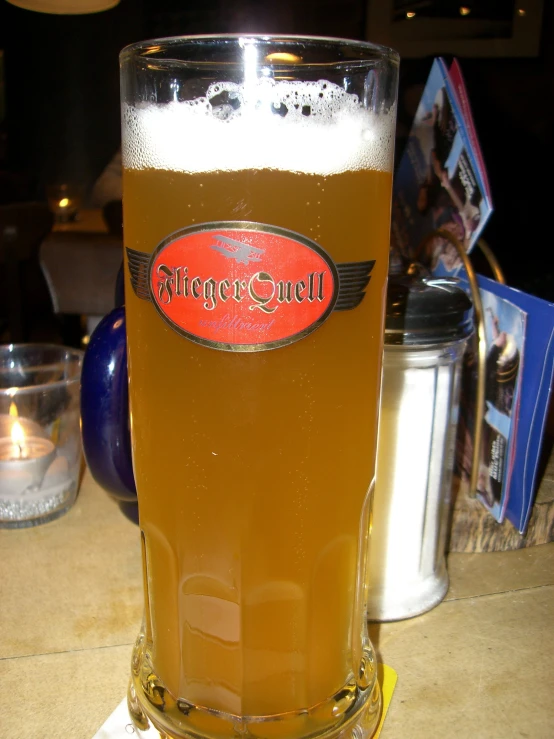 a tall glass of beer on top of a counter