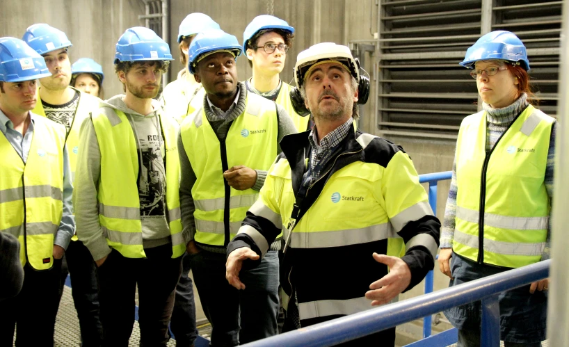 men in safety vests and hard hats talking while others look on