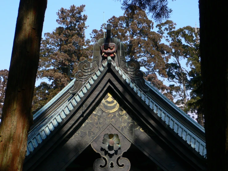 a building with a pointed roof with trees in the background