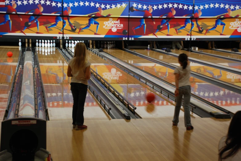 the bowling lanes are crowded with people playing bowling