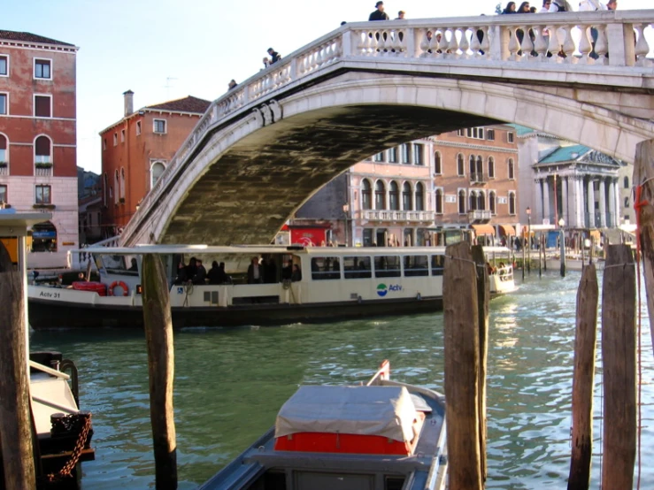 people on a boat traveling under a bridge