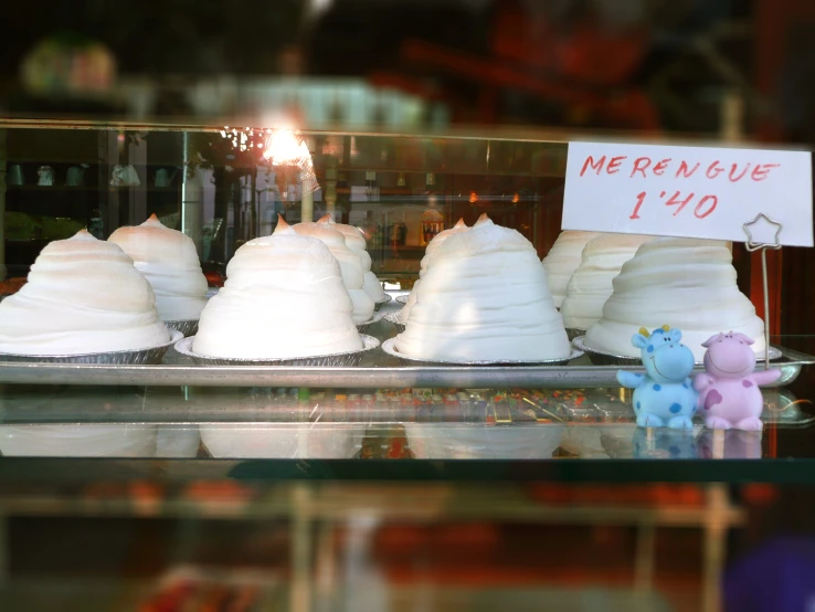 several rolls of icing wrapped in icing in front of a glass case