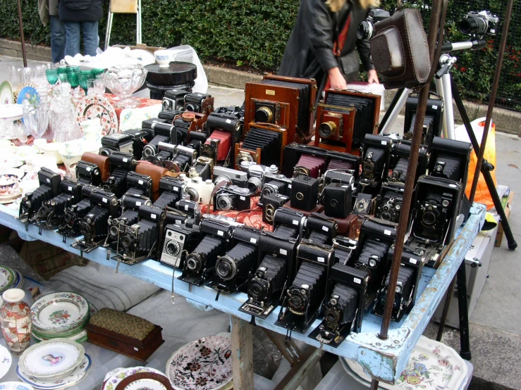 some old cameras sitting on display with a woman looking at them