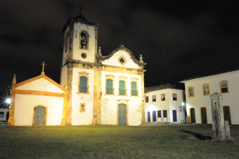 old church building illuminated in at night near cemetery