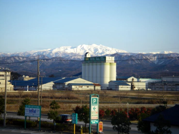 snowy mountains are beyond the industrial area
