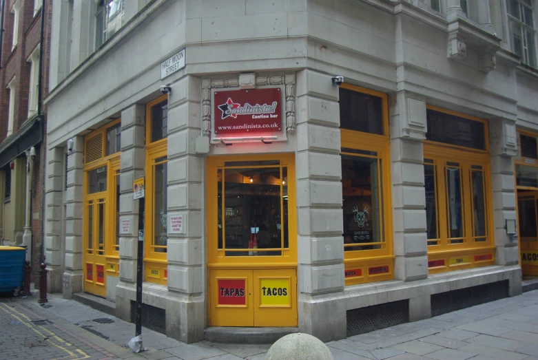 a picture of a building that is yellow with a red sign