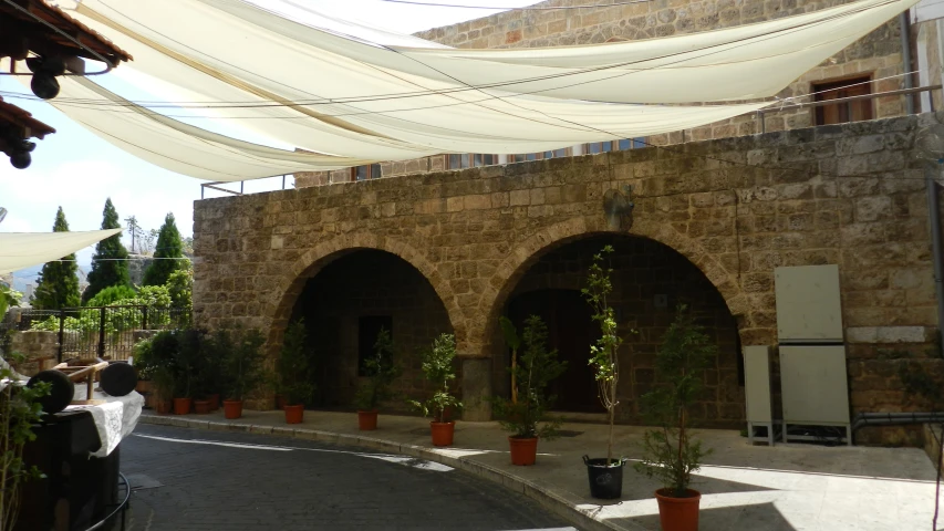 some people and a building with large columns and plants in them