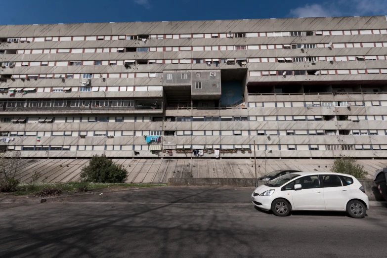 two cars parked in a parking lot with an old building in the background