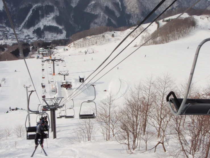 a snow covered ski slope with a ski lift going uphill