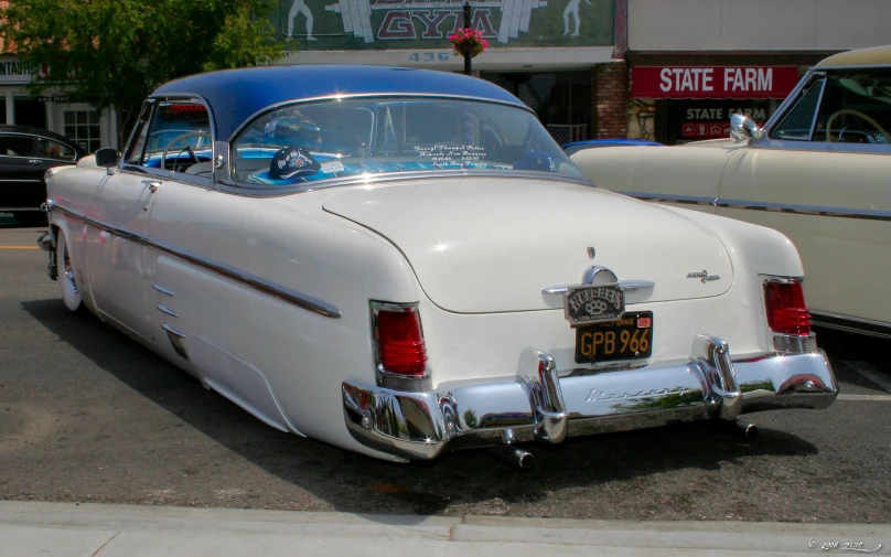 white cars lined up outside an antique car show