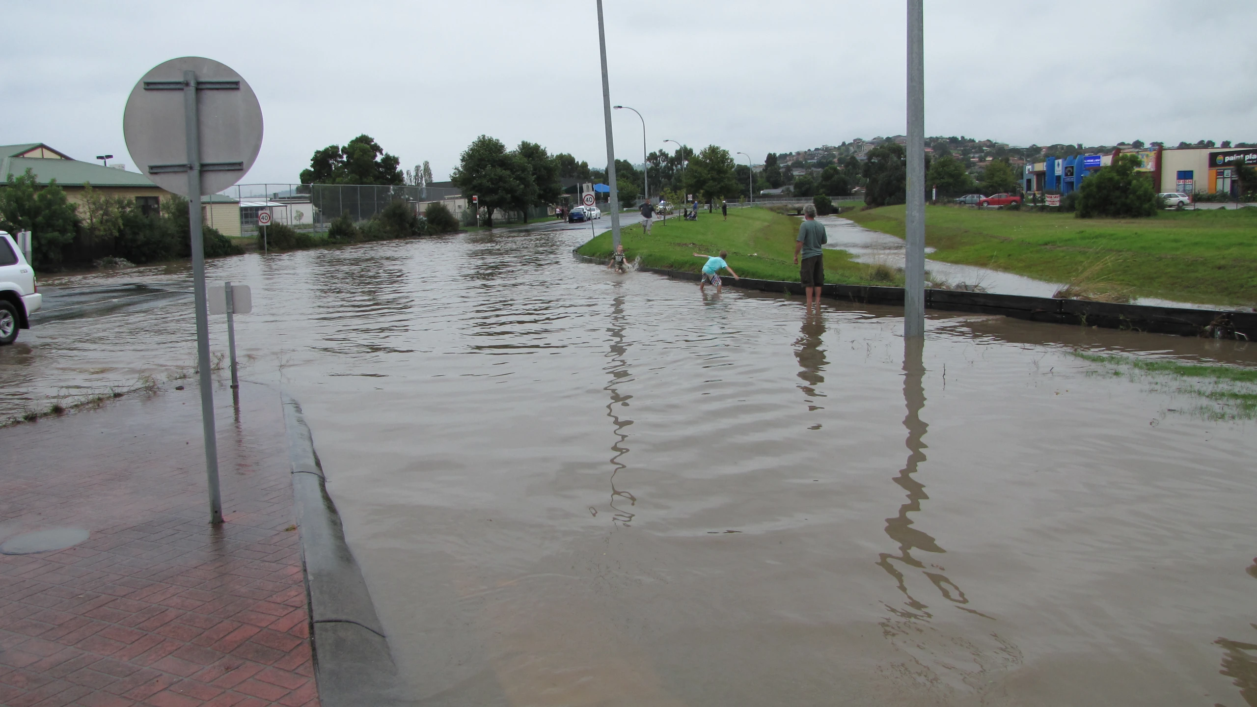 there are people in the flooded road with no cars