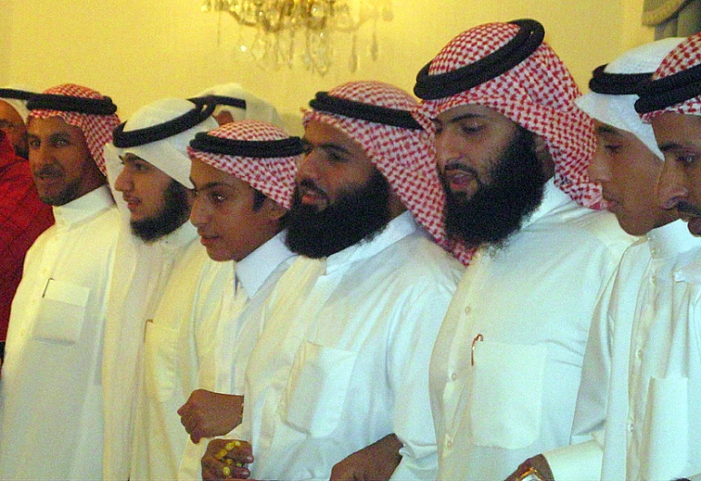 several men are lined up and wearing traditional clothes