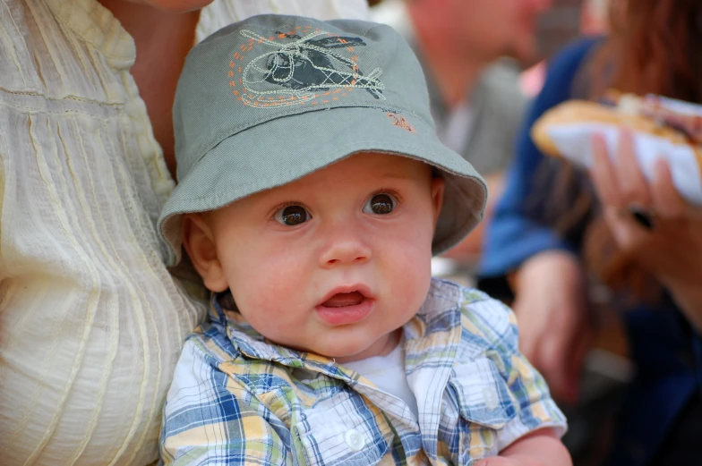 a baby in a hat is sitting down