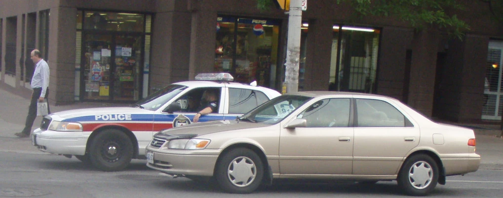 two police cars are shown side by side on a street