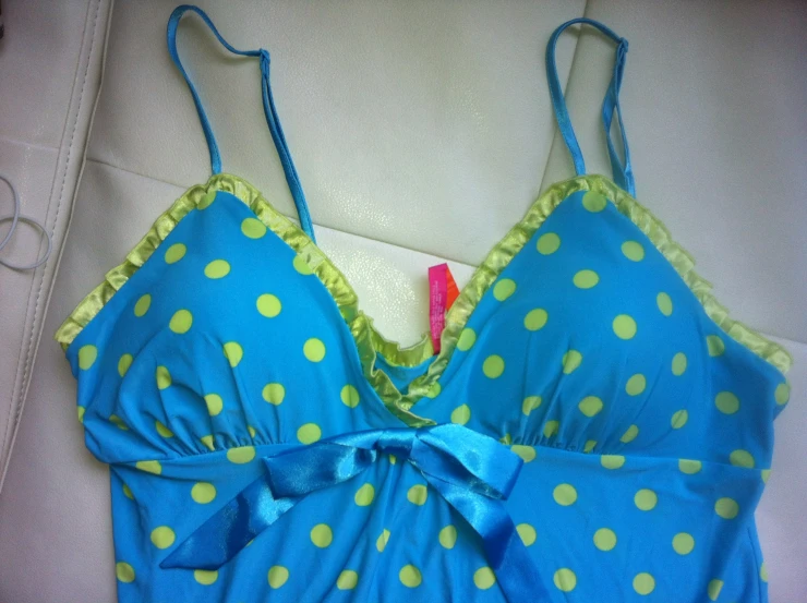 a bikini top with green polka dots and a blue ribbon