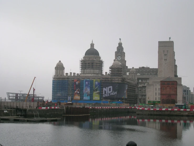 buildings along a river with a large billboard in the foreground