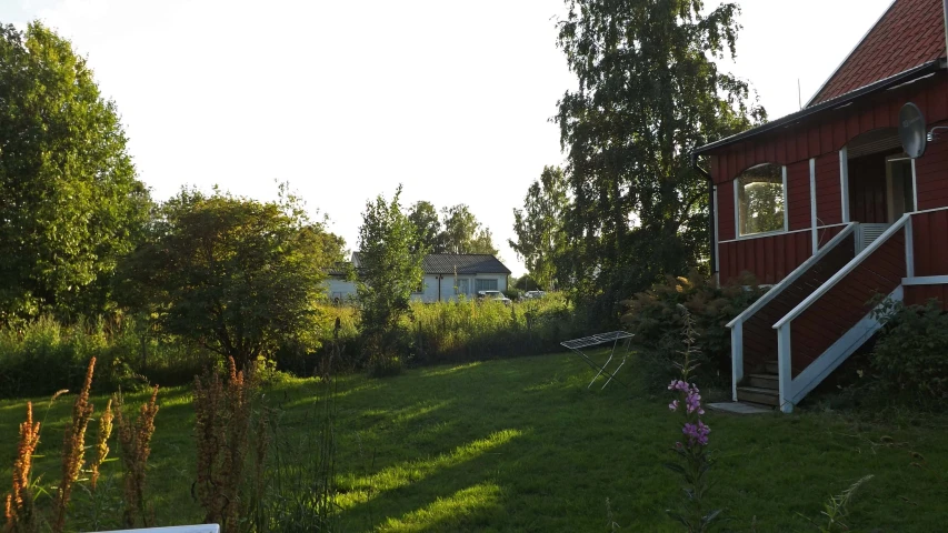 a red house in the grass with a grassy yard