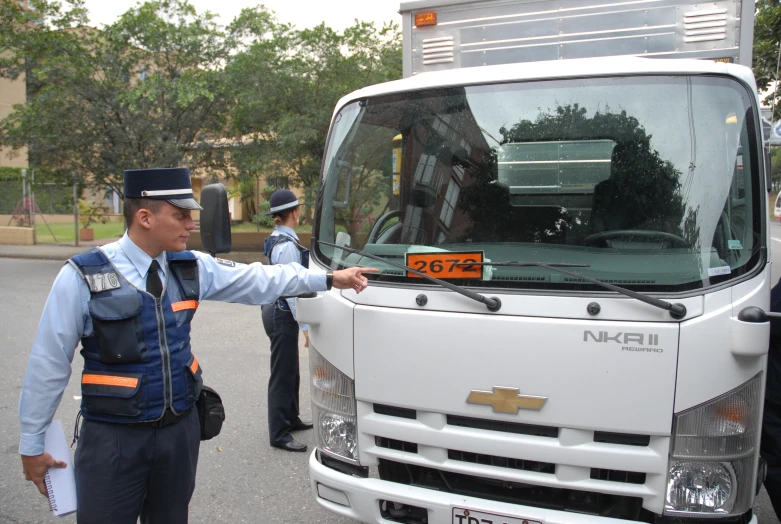 a truck driver stands in front of the door of a truck