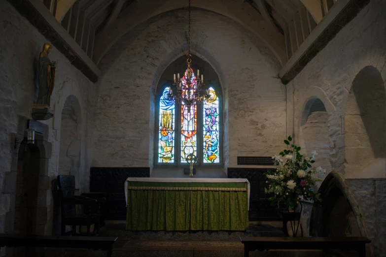 a church with a stained glass window and a green table cloth