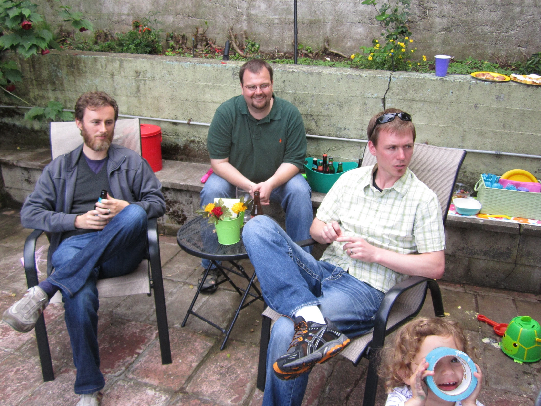 four men are sitting around on some chairs