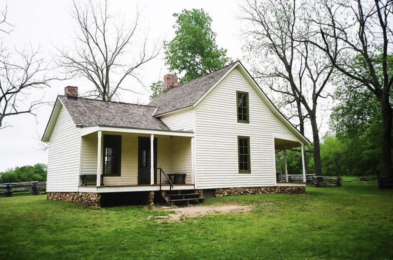 an old country house in the grass near some trees