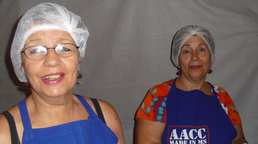 two elderly women who are wearing scrubber hats