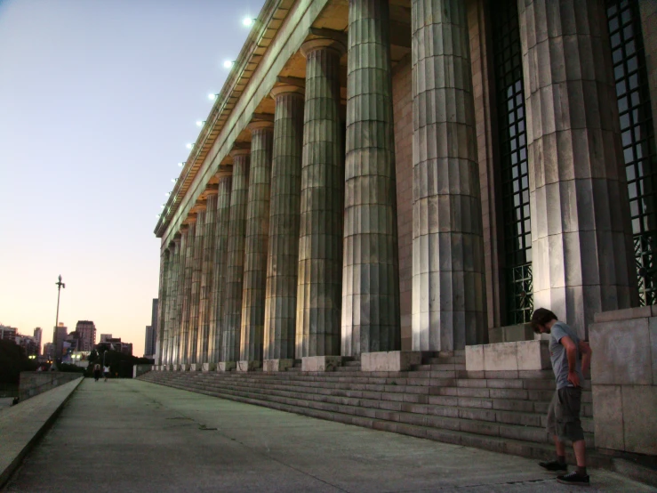 a man standing on the side of a building near stone steps