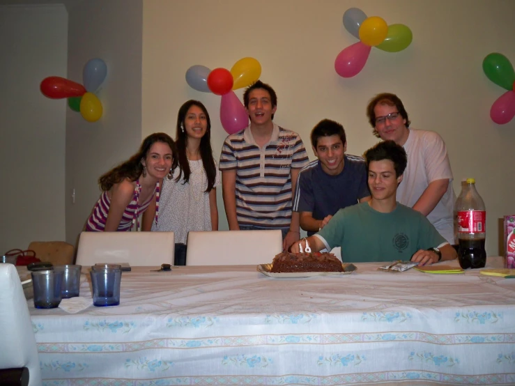 six s pose with balloons around the cake