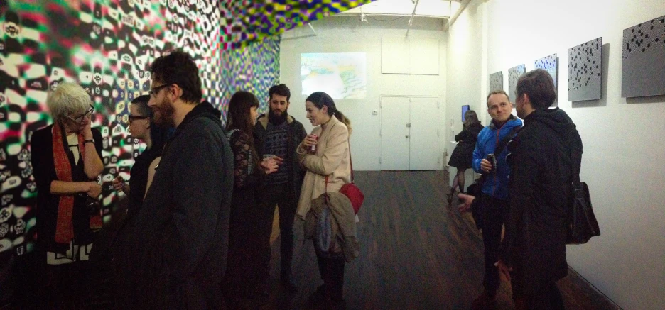 a group of people viewing artwork on a wall