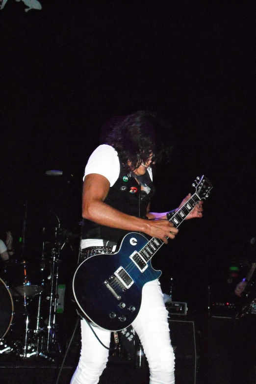 a man holding a black guitar on stage