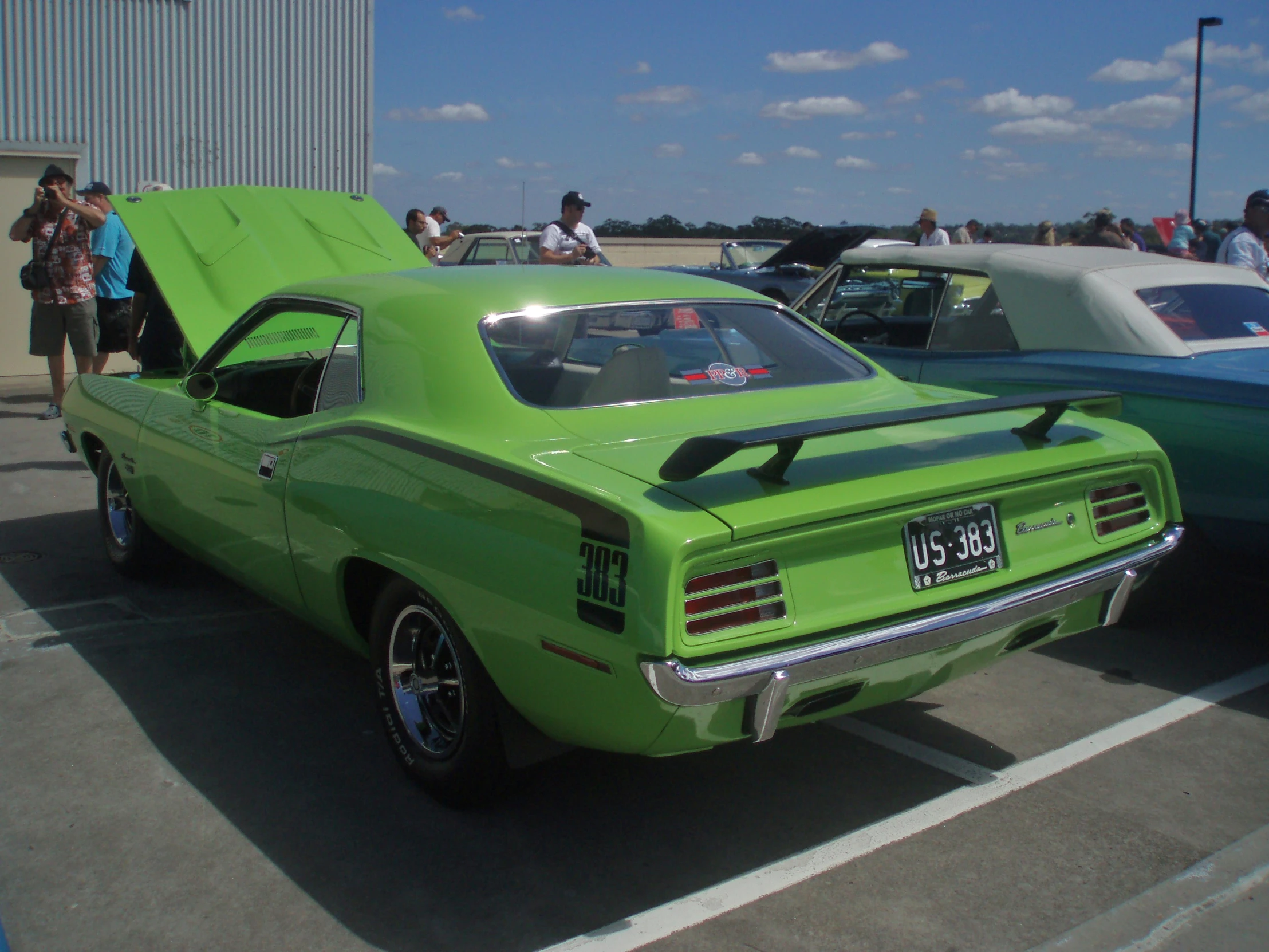 the green classic car is being presented