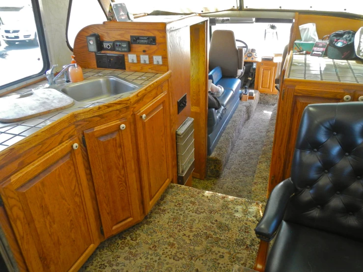 an rv kitchen that has some black chairs