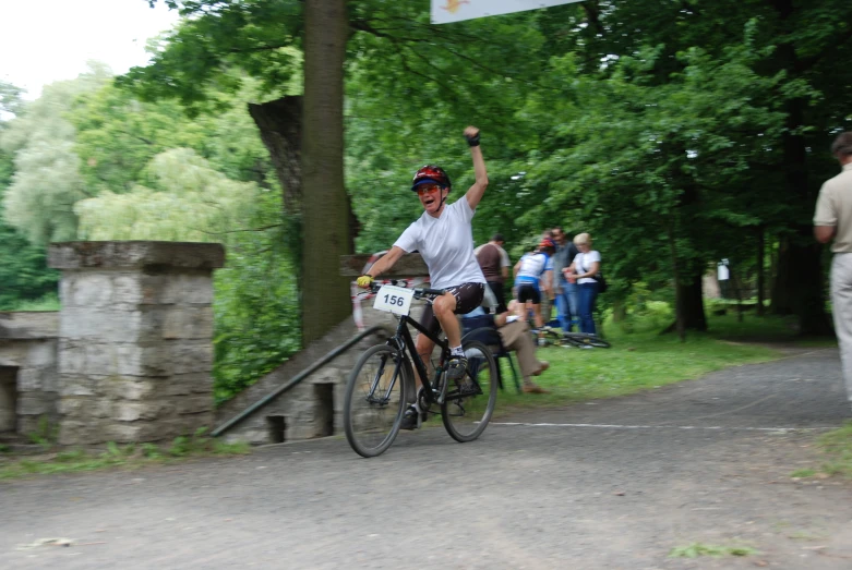 a person on a bike raises his hand up