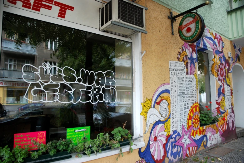 a store front with grafitti and street signs in the window