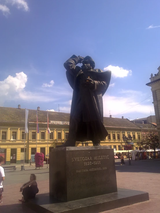 a man taking a picture with his cell phone of a statue