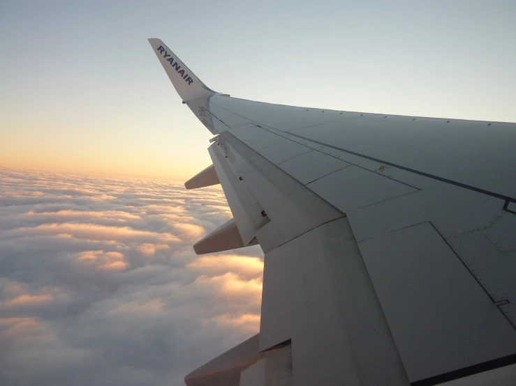 the wing of an airplane is shown as clouds and a blue sky