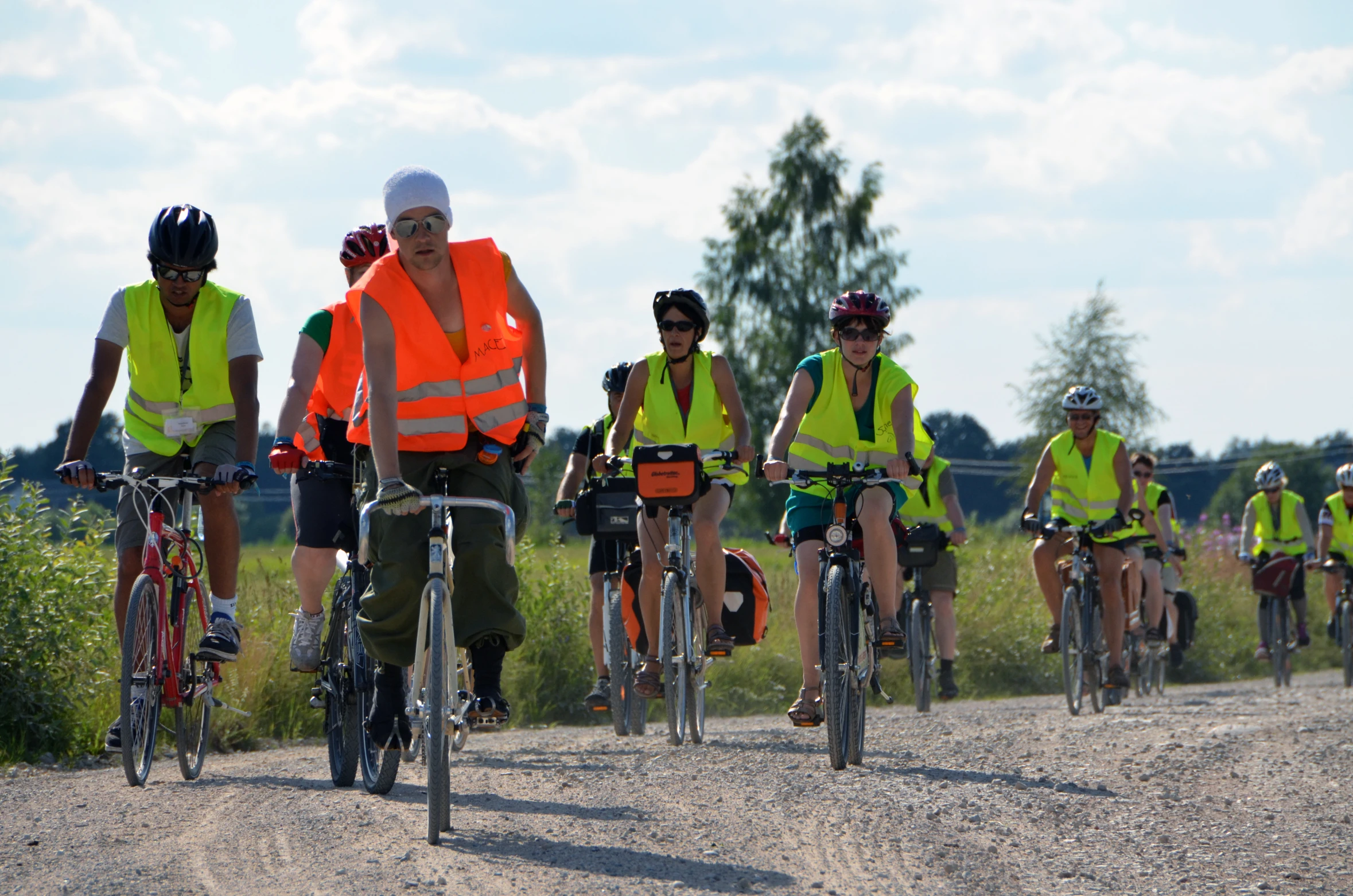 a group of people riding bicycles down a dirt road