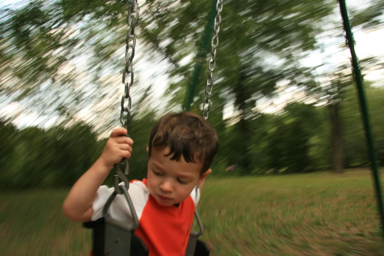 a  swinging on a swing set in a park