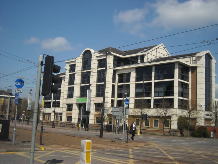 the white building has large windows near a road