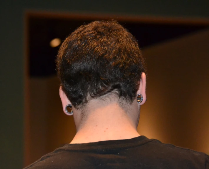 a close up view of the back of a person with earrings on her head
