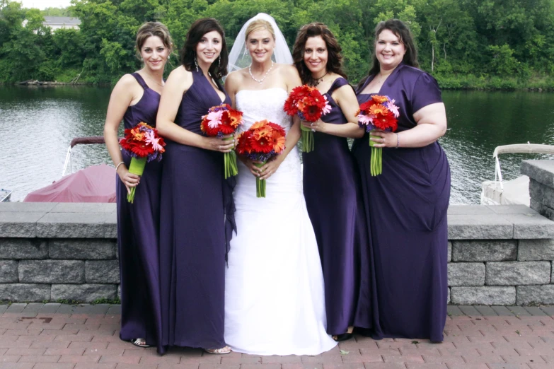 a bride and four bridesmaids pose with their bouquets