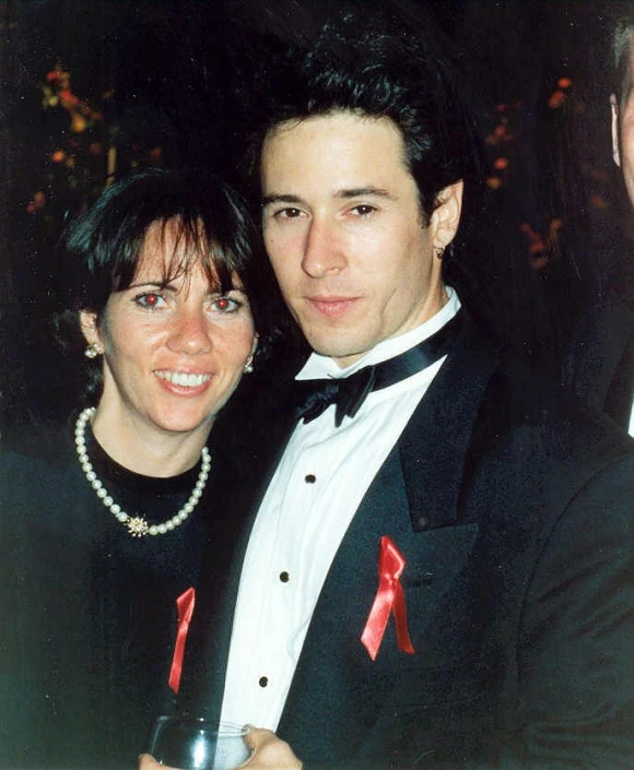 a woman is holding a man in a black suit