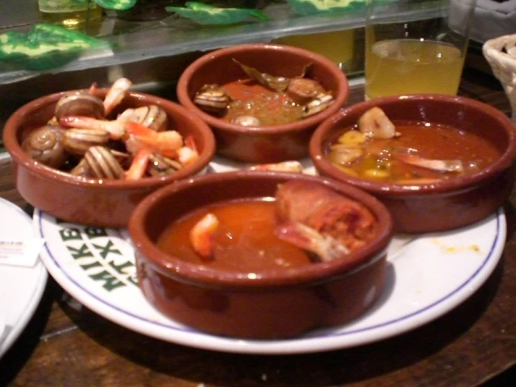 four bowls of food are shown on a plate