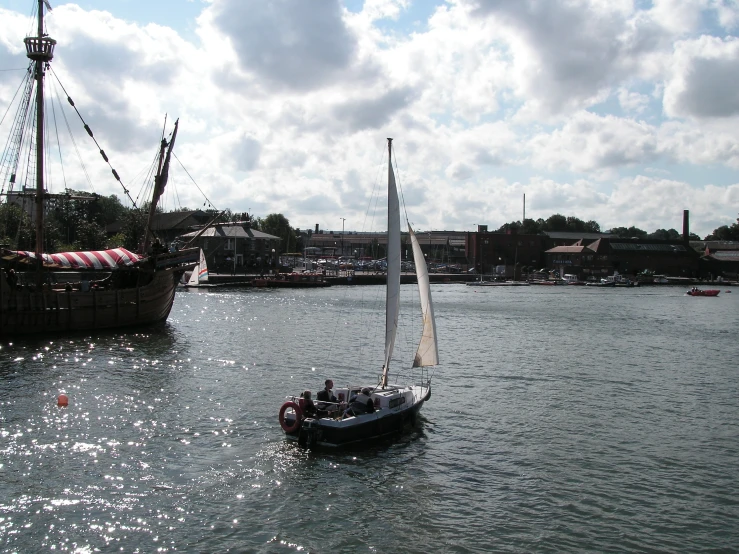 a small boat is floating in the water near a larger boat