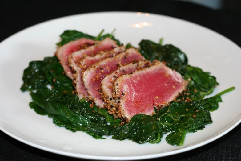 some rare meat that looks like spinach on a plate