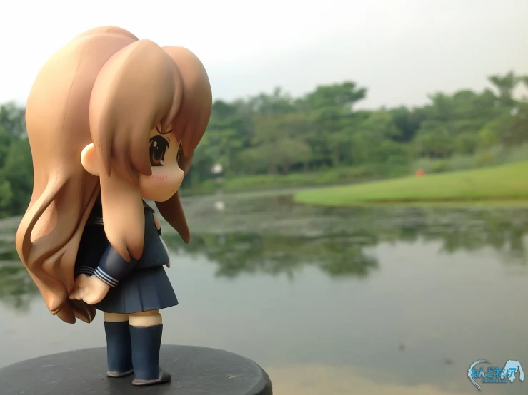 a toy model is sitting on a bench near water