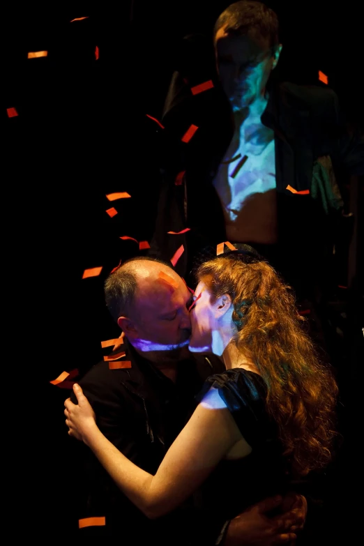 two people kissing each other while the light is off